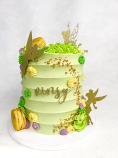 there is a green cake with gold decorations on the top and bottom that says fairy