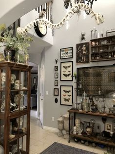 a living room filled with lots of clutter and decor on top of a hard wood floor