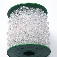 a spool of clear crystal beads on a white background with green trimmings