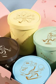 three ice cream containers sitting on top of each other next to boxes with cartoon drawings