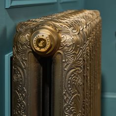 an ornate gold radiator in the corner of a room with blue walls and flooring