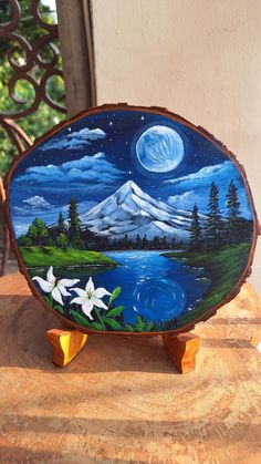 a painting on a piece of wood with flowers in the foreground and a full moon behind it