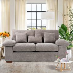 a living room scene with focus on the couch and table in front of the window