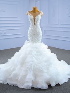 a white wedding dress on display in a room