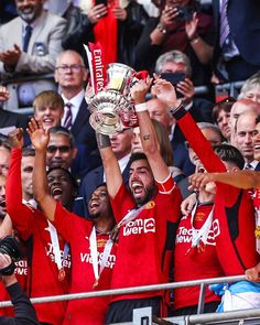 the manchester united team celebrate with the trophy