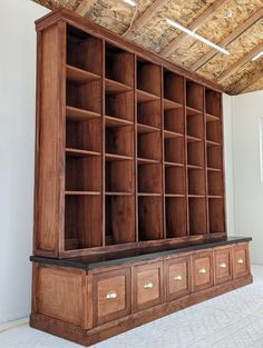 a large wooden bookcase with drawers in an unfinished room