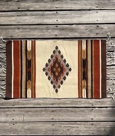 an old rug is laying on a wooden floor with fringes and beads around it