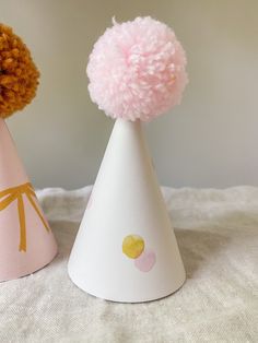 two party hats with pom - poms on them