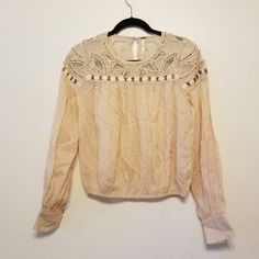 Nwot, Free People Slightly Cropped Crochet Top With Boho Stitching, Weaving, Beading & Sequined Details. Colors Of Cream, Tan, And Bronze. Long Cuffed Sleeves. Elastic At Hem And Also Along The Detailing On Shoulder. Beautiful! Armpit To Armpit 21" Length 21" Beaded Long Sleeve Summer Blouse, Bohemian Embellished Long Sleeve Blouse, Bohemian Long Sleeve Embellished Blouse, Long Sleeve Embellished Blouse For Festivals, Embellished Long Sleeve Blouse For Festival, Boho Stitching, Boho Blouse, Crochet Crop Top, Boho Blouses