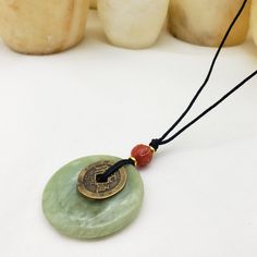 This pendant features genuine carnelian and jade, with a reproduction I-Ch'ing coin. Due to the genuine quality of the jade stone, the color will vary. The ancient Chinese tossed yarrow stalks and later coins to help make decisions that were based on the patterns of the toss as they related to the I Ch'ing, The Book of Change. Our pendant necklace hangs from a 36-inch cotton waxed cord.  There is a knot closure with bead to hold it in place artfully. This necklace comes shipped in a jewelry box Chinese Coin, I Ching, Coin Pendant Necklace, Accessories Bags Shoes, Turquoise Bead Necklaces, The Emperor, Jade Stone, Premium Gift, Jade Pendant