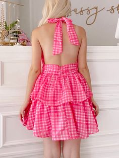 The Razzle Dazzle Dress is a raspberry pink, plaid ruffle open back dress. She features a halter neckline and an adjustable tie around the neck. Lined. Summer Halter Dress With Ruffles, Pink Mini Dress With Tie Back And Ruffled Straps, Summer Halter Dress With Ruffles For Brunch, Day Out Ruffled Halter Sundress, Pink Tie-back Backless Halter Dress, Pink Mini Dress With Smocked Back For Party, Flirty Ruffled Dresses For Picnic, Party Halter Dress With Smocked Back And Backless Design, Ruffled Halter Sundress For Day Out