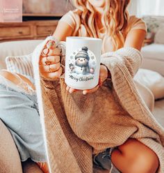 a woman sitting on a couch holding a coffee mug