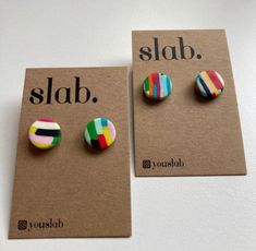 two pairs of colorful striped earrings on top of a brown card that says slab