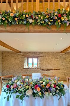 the table is set with flowers and greenery on it for an elegant wedding reception