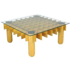 a glass and wood coffee table with geometric designs on the top, sitting against a white background