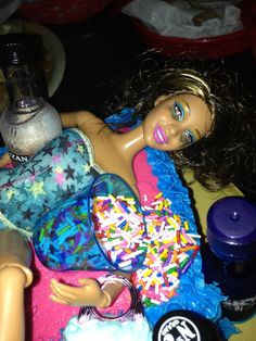 a barbie doll laying on top of a table next to a jar of condiments