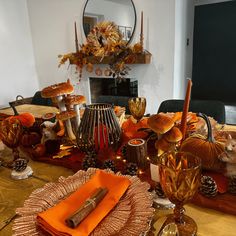 the table is set for thanksgiving dinner with orange napkins and other items on it