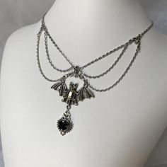 This gothic vampire inspired necklace is made with an antiqued silver plated bat. filigrees and findings, accented with sparkling glass crystals in JET BLACK. Decorated portion is 6" wide and centerpiece is 2 7/8" tall in the center.Necklace is adjustable 15-18" with a lobster clasp and chain extender in the back. If you would like a different length or stone color, please send us a message. Goth Jelewery, Witchy Metal Jewelry For Halloween, Gothic Pendant Necklace For Halloween, Gothic Sterling Silver Choker Jewelry, Gothic Sterling Silver Choker, Gothic Sterling Silver Choker Necklace, Elegant Metal Necklaces For Halloween, Halloween Gothic Pendant Jewelry, Halloween Gothic Pendant Necklace