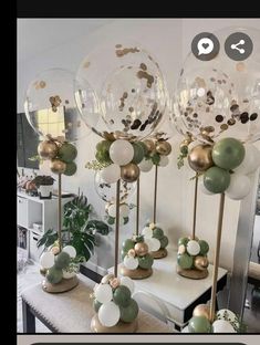 some balloons that are sitting on top of a table with gold and white decorations around them