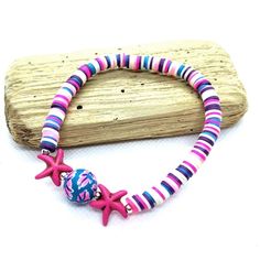 Pink Starfish Bracelet, Beach Bracelets for Women, Stretch Bracelet, Elastic Bracelet, Christmas Gift, Sister Birthday Gift, Beach Jewelry ~~~~~~~~~~~~~~~~~~~~~~~~~~~~~~~~This perky hot pink vinyl heishi starfish bracelet features a flower millefiori clay focal bead, flanked by two hot pink starfish.  The beads are made from hard vulcanized rubber and sometimes old phonograph records and look like tiny colorful washers.  This type of bracelet is great for stacking with lots of other bracelets to Adjustable Pink Holiday Jewelry, Adjustable Pink Jewelry For Holiday, Handmade Star Bracelets For Beach, Pink Strand Bracelets For Beach Season, Adjustable Star Bracelets For The Beach, Bohemian Style Adjustable Holiday Bracelets, Adjustable Starfish Bracelets For Beach Season, Adjustable Starfish Bracelet For Beach Season, Adjustable Strand Bracelet With Starfish Charm