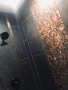 a bathroom with a toilet and shower head in the corner next to a tiled wall