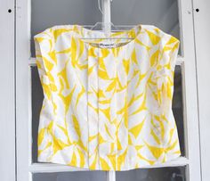 This Vintage 1980's  Crop Top is in good vintage condition. This adorable top has a white and yellow floral pattern that looks tropical or like a Hawaiian top. The only issue with the top is that the tag is a little frayed but the shirt itself looks brand new. Very gently worn and very cute. Size: XS Measurements laying flat: Length - 17 inches Armpit to armpit - 16 inches Bottom of Crop Top - 19 inches White Cotton Tops With Tropical Print, Fitted White Tops With Tropical Print, Fitted White Top With Tropical Print, Yellow Tropical Print Tops For Spring, Vintage Yellow Floral Print Tops, White Summer Tops With Lemon Print, White Summer Top With Lemon Print, White Lemon Print Summer Top, Vintage Tops With Tropical Print For Spring