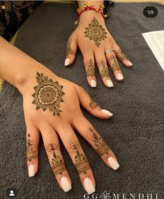 two hands with henna tattoos on them