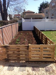 a wooden garden bed in the middle of a yard