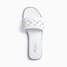 Combine the effortless style of a ladies slip on with the elegance of classic pearls and mini studs. This classic white pearl-embellished leather sandal is the perfect marriage of style + comfort at a price that won't break your wallet. Leather upper and lining Extra padded insole Flexible rubber sole Medium width .5" heel Made in Spain Spring Open Toe Footbed Sandals With Studded Outsoles, Spring Open Toe Sandals With Studded Rubber Outsoles, White Sandals With Studded Rubber Outsoles For Spring, White Studded Open Toe Sandals, Casual Spring Footbed Sandals With Studded Rubber Outsoles, Pearl Sandals, Mini Studs, Footbed Sandals, Perfect Marriage