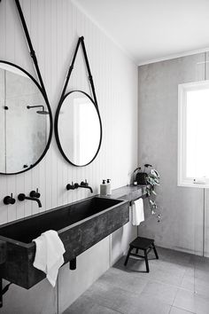 a black and white photo of a bathroom with two mirrors on the wall above the sink