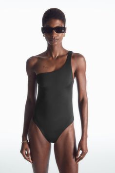 ONE-SHOULDER SWIMSUIT - BLACK - COS Sleek Summer Swimwear, Sleek Swimwear For Poolside Summer, Sleek Nylon Bodysuit For Summer, Sleek Nylon Swimwear For Summer, Sleek Seamless Swimwear For Summer, Sleek Second-skin Swimwear For Summer, Sleek Second-skin Swimwear For Beach, Sleek Fitted Swimwear For Summer, Sleek Fitted Summer Swimwear