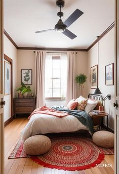 a bedroom with a bed, ceiling fan and rug on the floor in front of it