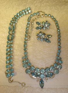 Lovely Vintage EISENBERG ICE Clear & Sparkling Light Blue Rhinestone Parure A Great Fashion Accessory & Gift Item! This is a very beautiful EISENBERG ICE light blue and clear prong set rhinestone parure and it is in very good vintage condition. All rhinestones are present and shining. The rhodium back of each piece is signed with the Eisenberg Ice logo. The necklace measures about 13" long with a 3 1/2" extension.The bracelet measures approximately 7" long and the earrings are 1 1/4" by 1". This 3 piece set probably dates from the 1950's to 60's.     Please view the photos before bidding. This parure is sold "as is". If you are interested in other items, please visit our eBay store at https://stores.ebay.com/thecosartistart. We are always adding to our inventory. Thank you for viewing our Ice Logo, Vintage Jewelry Antique, Antique Costume Jewelry, Vintage Cameo, Vintage Antique Jewelry, Brooch Jewelry, Old Jewelry, Blue Rhinestones, Vintage Rhinestone