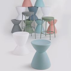 several different colored stools and tables against a white background