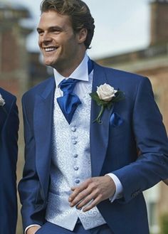 two men in blue suits are smiling for the camera