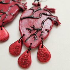 two red heart shaped pendants hanging from strings