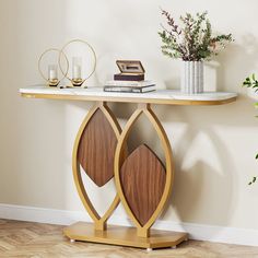 a table with some books on top of it next to a potted plant and vase