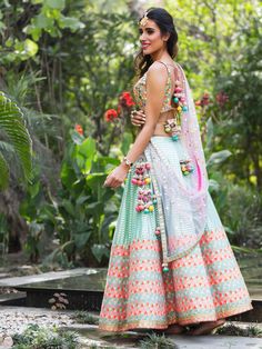 Our gorgeous rainbow mirror work choli has an open back with tassels. It is paired with an aqua lehenga skirt with tassels at the side. The outfit is completed with a net mukaish dupatta. Sangeet Lehengas, Lehenga Ideas, Sangeet Lehenga, Orang India, Designer Bridal Lehenga Choli, Raw Silk Lehenga, Sabyasachi Lehenga, Mehendi Outfits, Lehnga Dress