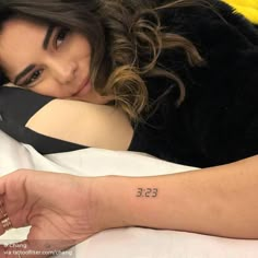 a woman laying in bed with her arm around the edge of her body and writing on it