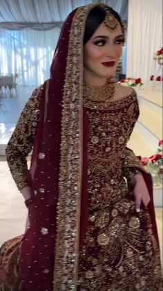 a woman in a red and gold bridal gown