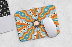 a mouse pad with an abstract design next to a laptop