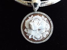 "This is an amazing cameo bezel set in Italian silver with a permanent bail (8mm). The bezel setting and bail have cz's encrusted around the entire rose cameo. It is carved in sardonyx shell and measures 35 mm (1.37\") round. This a beautiful piece to give as a gift or for yourself. It is carved by our carver, Romano. This pendant comes with a 18\" stainless steel chain. This is a rose that will live forever! This pendant comes with a black velvet box and certificate of authenticity. Item Number Luxury Cameo Jewelry, Luxury Cameo Medallion Jewelry, Elegant Cameo Round Pendant Jewelry, Luxury White Gold Cameo Jewelry, Luxury Silver Cameo Jewelry, Twisted Ribbons, Filigree Pattern, Live Forever, Diamond Settings