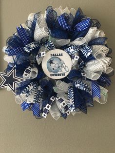 a football wreath hanging on the side of a wall with a star and cowboys logo