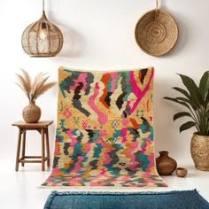 a colorful rug is on the floor next to some potted plants and other decorative items