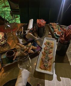 a table topped with lots of food next to wine glasses and plates filled with food