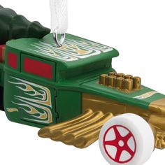 a green and gold toy car with white wheels