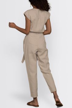 Our Evening Chai Hemp V-Neck Jumpsuit - a chic V-neck ensemble designed for stylish versatility. Featuring micro sleeves and straight-cut legs, this trendy jumpsuit offers a voguish look, perfect from day to night. Crafted with a tapered fit and a concealed placket, this jumpsuit has functional pockets on both sides, adding practicality to its stylish appeal. Elevate your wardrobe with this contemporary piece, ideal for brunch, evening events, or casual outings Wash in cold water or dry clean on Chic Fitted V-neck Pantsuit, Chic Spring Pantsuit With Tie Waist, Elegant Fitted Pants With Tie Waist, Elegant Sleeveless Linen Jumpsuit, Elegant Fitted Linen Pantsuit, Chic Linen Jumpsuits And Rompers With Short Sleeves, Fitted V-neck Pantsuit For Workwear, Chic Short Sleeve Workwear Pantsuit, Chic Short Sleeve Pantsuit For Work