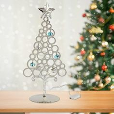 a christmas tree made out of circles and stars on top of a wooden table next to a christmas tree