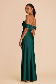 a woman in a long green dress with one shoulder open and the other half closed