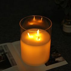 a lit candle sitting on top of an open book